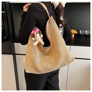 Close-up of woven straw tote bag with mesh texture and plush dog charm in a kitchen