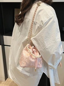 Pink bucket bag with 3D floral jacquard, pearl handle and gold chain strap on model