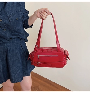 Detail of red vintage pillow bag featuring motorcycle style pockets and silver hardware