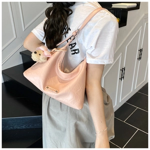 Sac sous le bras rose en croissant avec breloque ours en peluche vue de côté chic