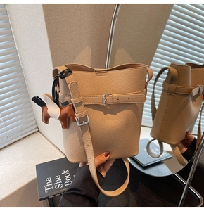 Detailed views of a beige lychee leather bucket bag with a cute horse charm