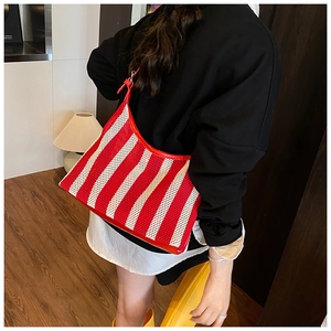 Détail du sac hobo en maille à rayures rouges et blanches avec finitions en cuir et bandoulière