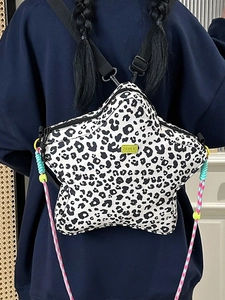 Star shaped backpack featuring leopard print canvas and fluorescent green logo detail