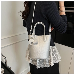 Silver bucket bag with litchi grain texture and elephant charm shown on model