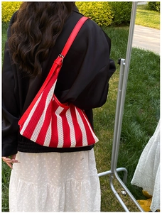 Détail du sac cabas en maille à rayures rouges et blanches avec bandoulière réglable