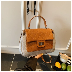 Detail of vintage quilted leather flap and metallic twist lock on a shoulder bag