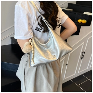 Vue détaillée du sac croissant argenté en tissu métallisé plissé avec breloque en fourrure