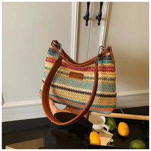 Gros plan détaillé d'un sac tressé arc-en-ciel avec garniture en cuir brun et fermeture