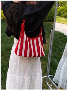 Détail du sac fourre-tout en résille rayé rouge et blanc avec bandoulière en cuir
