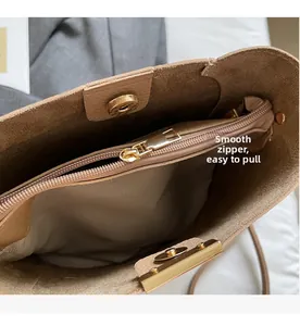 Close-up of the smooth metal zipper and magnetic closure inside the tan bucket bag