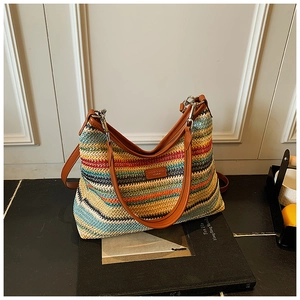 Gros plan détaillé du sac cabas tissé arc-en-ciel avec anses en cuir marron et boucles métal