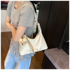 Détail du sac Hobo blanc crème avec bandoulière réglable et breloque ours mignonne