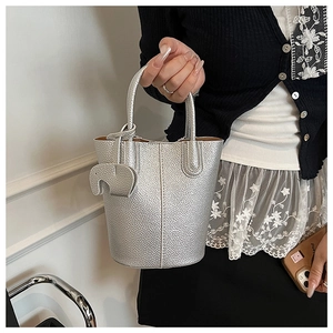 Detail of silver grain texture bucket bag with cute elephant charm and hand straps