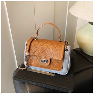 Close-up of quilted leather flap and woven texture on a chain crossbody bag
