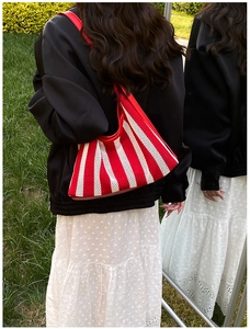 Détail du sac fourre-tout en maille rayée rouge et blanc avec garniture en cuir chic