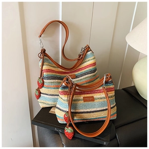Détail d'un sac à bandoulière tissé multicolore avec fermeture éclair et breloque fraise
