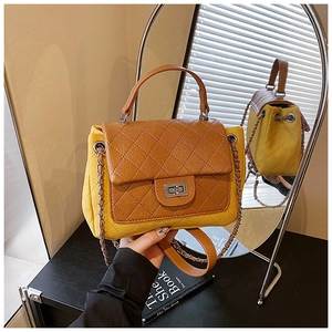 Detail of contrast color quilted crossbody bag with gold chain strap and turn-lock