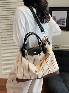 Large striped canvas tote bag with black leather handles and crossbody strap
