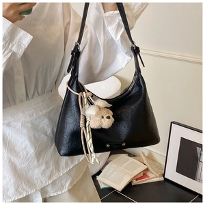 Détail du sac à bandoulière en cuir PU plissé noir avec un adorable pendentif chien en peluche