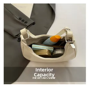 Internal capacity of white faux leather dumpling bag showing makeup items and zipper pocket