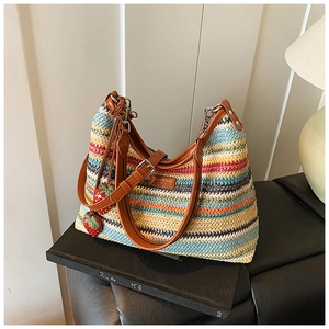 Détail du sac à bandoulière tissé coloré avec breloques fraises et lanière en cuir