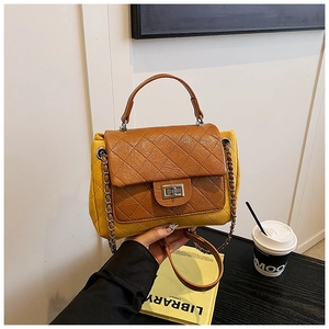 Detailed shot of brown and yellow quilted crossbody bag with a metal twist lock closure