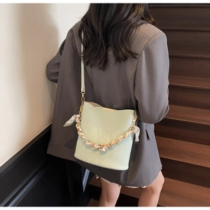 Détail du sac seau vert clair avec foulard léopard sur chaîne métallique