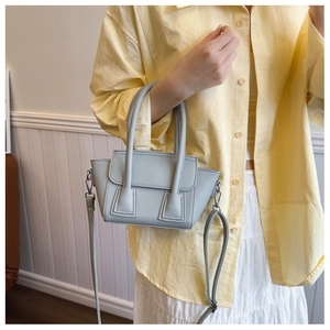 Detail of light blue lychee pattern leather bucket bag with silver hardware and shoulder strap