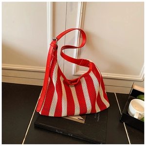 Détail du sac hobo en maille rayée rouge et blanc avec bandoulière réglable en cuir rouge