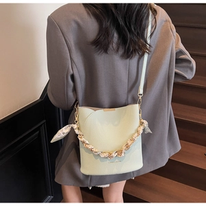 Détail du sac seau vert menthe avec texture litchi et poignée en foulard de soie