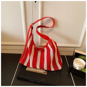 Détail du sac fourre-tout en maille rayée rouge et blanc avec anse en cuir de luxe