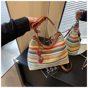 Détail d'un sac cabas en paille arc-en-ciel avec bandoulière cuir et fraises décor