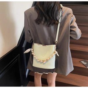Détail du sac seau vert menthe avec texture litchi et poignée chaîne foulard léopard