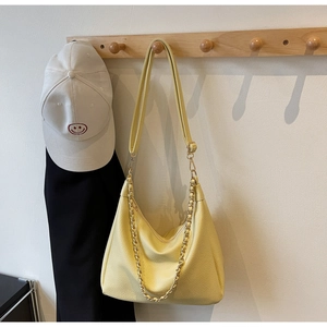 Detail of yellow lychee-textured hobo bag with adjustable strap and gold metal chain