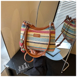Détail du sac à bandoulière tissé arc-en-ciel avec garniture en cuir et breloques fraises
