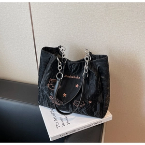 Détail du sac cabas matelassé noir avec broderie chat rose et bandoulière en chaîne