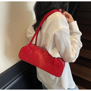 Sac baguette rouge en cuir synthétique sur modèle avec zip argenté et bandoulière