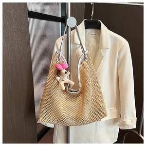 Detailed view of woven straw tote texture with silver leather straps and cute puppy charm