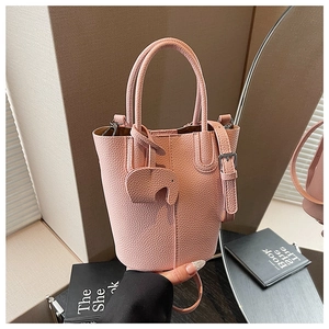 Detail of pink lychee grain leather bucket bag with cute elephant pendant and shoulder strap