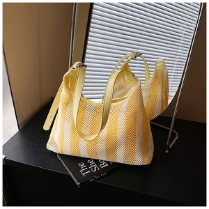 Détail du cabas en maille rayée jaune et blanc avec bandoulière en cuir réglable