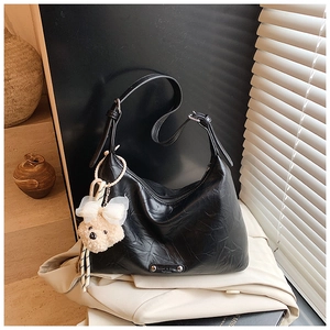 Détail du sac hobo plissé noir avec sangle réglable et breloque ours en peluche