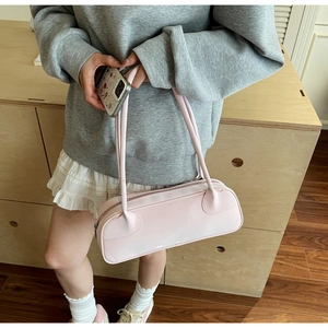 Minimalist light pink leather handbag with slim dual straps shown from a top-down angle
