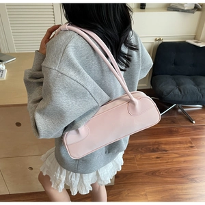 Detailed side view of pink leather minimalist shoulder bag with slim double straps