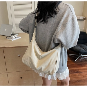 Detail of adjustable strap and silver buckle on a minimalist large canvas hobo bag