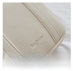 Close-up of cream lychee texture leather with fashion embossed letters and stitching