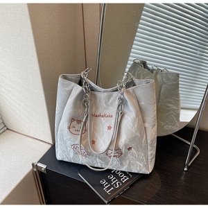 Détail du sac cabas métallisé argenté avec broderie de chat et bandoulière chaîne