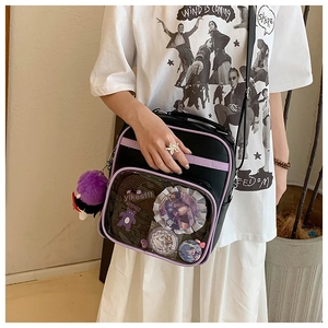 Detail of black ita bag with purple trim and transparent window showing anime badges