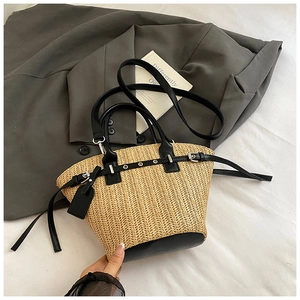 Detailed close-up of woven straw texture with black leather accents and silver buckle