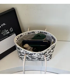 Interior view showing the large capacity with pockets of the cow print tote bag
