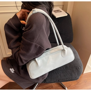 Chic light blue baguette bag with dual slim straps shown in a modern urban lifestyle setting